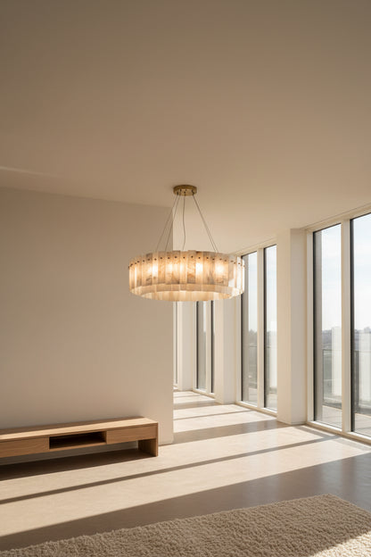 A Spanish alabaster double-tier pendant light with a brass canopy, hanging and illuminating a room with soft amber and ivory tones.
